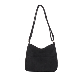 Minimalist black corduroy crossbody bag with adjustable strap and zip closure on white background