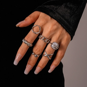 Detailed view of silver geometric ring set with chain and resin patterns on hand