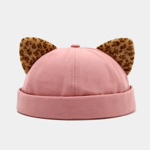 Detail of pink brimless docker cap featuring leopard print cat ears with gold threads