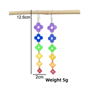 Rainbow acrylic four-leaf clover long drop earrings hanging on a branch