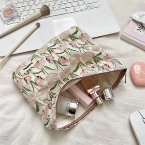 Détail d'une trousse de maquillage en toile à motifs tulipes roses montrant sa capacité