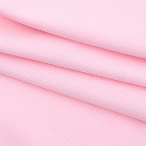Detailed close-up of pink knit fabric texture showing high-quality stitching and softness