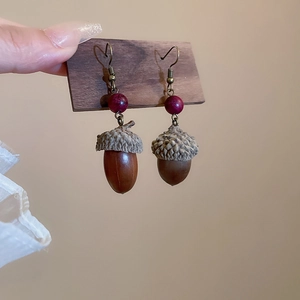 Detail of acorn-shaped drop earrings with purple beads and antique bronze hooks