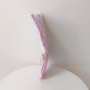 Detailed view of a pink and white plush Christmas stocking gift bag in clear packaging
