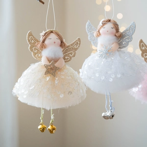 Christmas angel tree ornament with sequined mesh skirt and wings in warm bokeh setting