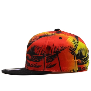Detail of snapback hat featuring tropical palm print and black brim with silver sticker