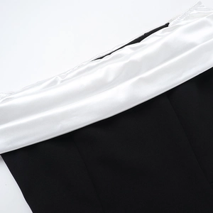 Detailed view of black matte fabric stitched with white satin on a slim fit dress