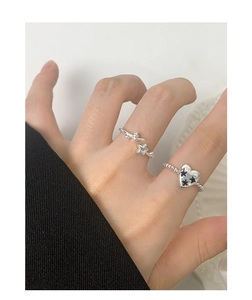Detail of silver S925 star and heart beaded rings worn on a hand for fashion styling