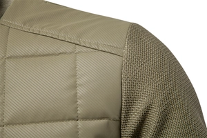 Detail of olive quilted fabric and textured knit patchwork on a men's jacket shoulder