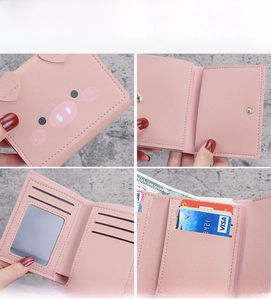 Macro detail of pink piglet short wallet showing internal card slots and ID window