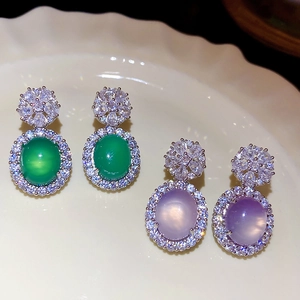 Détail de boucles d'oreilles vintage en calcédoine ovale verte et violette avec zircons