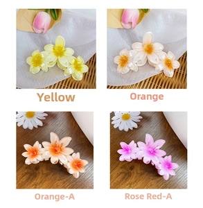 Detail of candy-colored resin plumeria flower hair claws in four vibrant gradient shades
