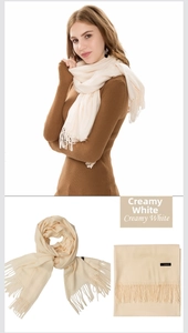 Detailed texture of creamy white cashmere scarf featuring soft fabric and fringe tassels