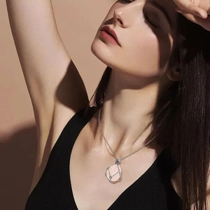 Dettaglio del cristallo rosa in un ciondolo geometrico d'argento indossato da una modella