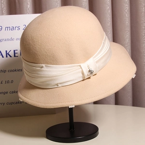 Detail of wool cloche hat featuring ivory silk ribbon and elegant pearl embellishments