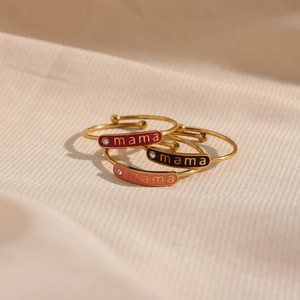 Detail of mama rings with colorful enamel inserts and small diamonds in gold finish