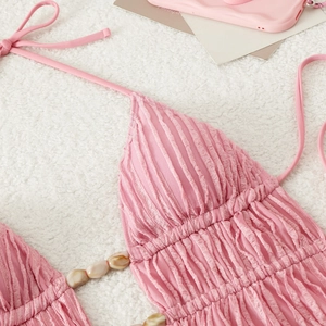 Close-up of pink pleated halter bikini with bohemian shell bead detail and plissé texture