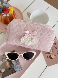 Pink heart quilted storage bag with silk bow and lace trim in a kawaii aesthetic setting