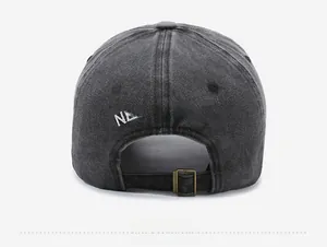 Detail of dark gray washed denim cap featuring NEW YORK embroidery and metal strap buckle
