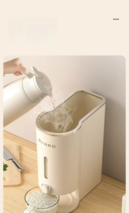 Close-up of cream white grain dispenser with clear window and metal trim for rice storage