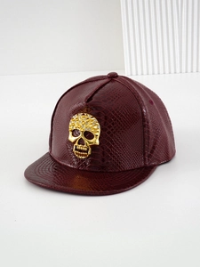 Macro shot of dark red snake pattern leather texture and golden skull with rhinestones