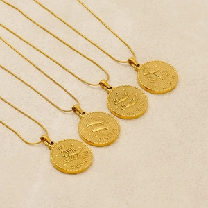 Detailed view of gold coin necklaces featuring embossed Scorpio, Pisces, Gemini, and Libra signs