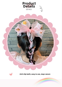 Detailed view of pink organza bow hair clip with floral embroidery on girl's hair