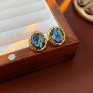 Macro shot of French vintage 18K gold-plated earrings with iridescent abalone shell inlay