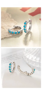 Detailed macro view of silver hoop earrings with five round blue turquoise stones