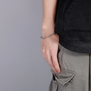 Close-up of a silver-toned coffee bean link bracelet worn on a model's wrist