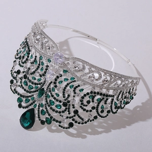 Detailed close-up of a silver crown featuring emerald stones and teardrop pendant