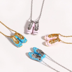 Detailed close-up of mini ballet slipper pendants in pink and blue on dainty O-chains