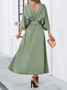 Detail of elegant backless green satin dress with tie closure and matching waist belt