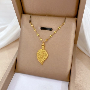 Detailed view of leaf pendant gold necklace with Chinese engraving in a jewelry box