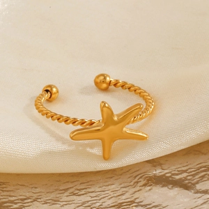Golden starfish open ring with twisted rope texture band on silk fabric background