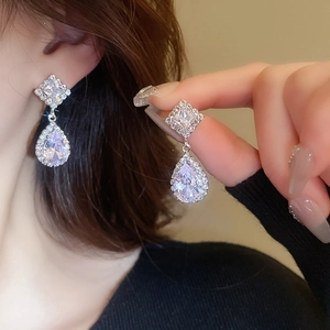 Detailed view of silver zircon geometric drop earrings with sparkling clear stones