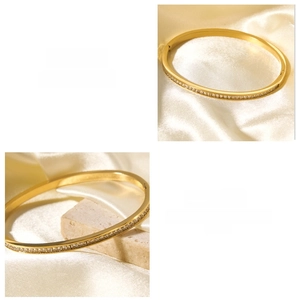 Dettaglio ravvicinato del bracciale in acciaio al titanio placcato oro 18k con zirconi