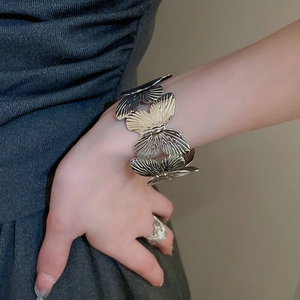 Silver butterfly bracelet and ring set with textured wings on a female model