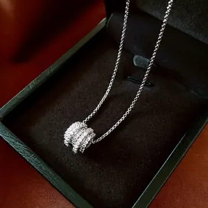Elegant silver cylinder pendant necklace with sparkling cubic zirconia on green velvet