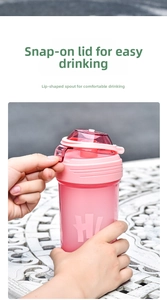 Close-up of pink fitness shaker bottle featuring a secure red flip cap and drinking spout