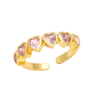 Close-up of heart-shaped pink zircons on gold adjustable ring with polished finish