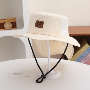 Detail of beige kids sun hat with breathable mesh, neck flap and leather lucky face patch