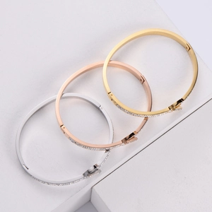 Three-piece bangle set in gold, rose gold, and silver finishes with crystal pavé detailing