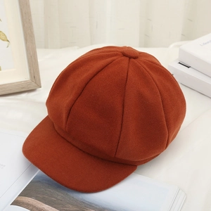 Detailed close-up of caramel wool newsboy hat texture and fabric on a white cloth