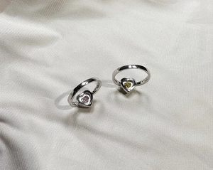 Macro detail of 925 silver rings featuring heart-shaped pink and yellow gemstone settings