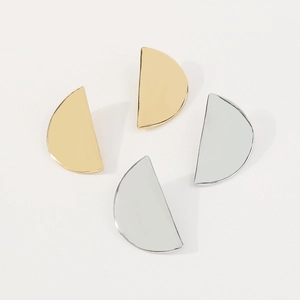 Detailed view of semi-circular metallic earrings in polished gold and silver finishes