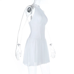 Détail de la robe licou blanche avec jupe en mousseline plissée et taille cintrée