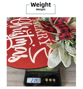 Detail view of wooden Merry Christmas wreath decoration showing its 214g weight on scale