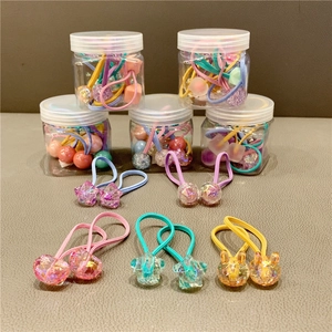 Detailed view of colorful elastic hair bands with heart and star charms in plastic jars