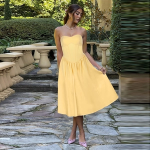 Elegant yellow strapless corset midi dress with vintage French style in a sunny garden